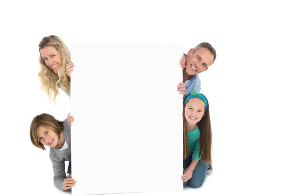 Семья улыбается на камеру, держа плакат — стоковое фото