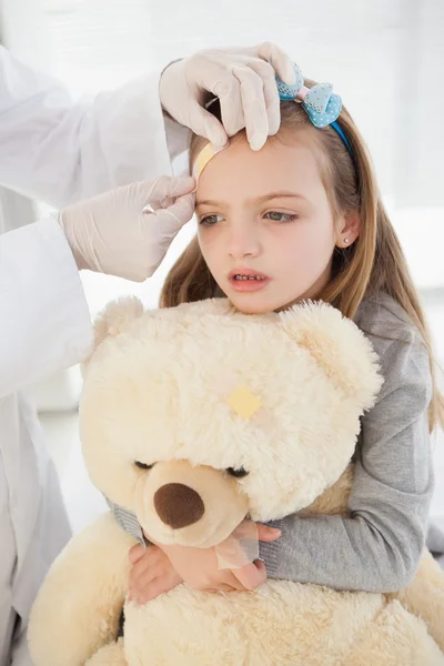 Girl getting bandage on forehead — Stock Photo, Image