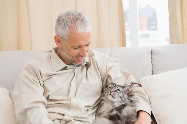 Uomo con gatto sul divano — Foto Stock