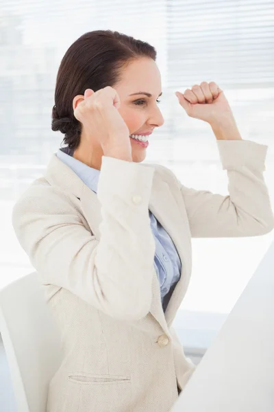 Empresária sentada e celebrando no trabalho — Fotografia de Stock