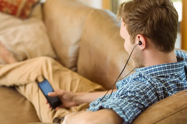Человек слушает музыку на диване — стоковое фото