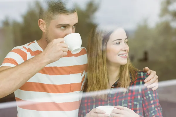 Paar kijkt uit raam — Stockfoto