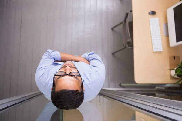 Empresario de pie contra la pared de vidrio — Foto de Stock