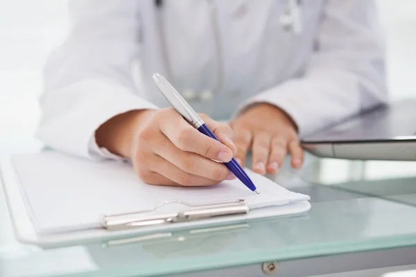 Arzt schreibt medizinische Notizen auf — Stockfoto