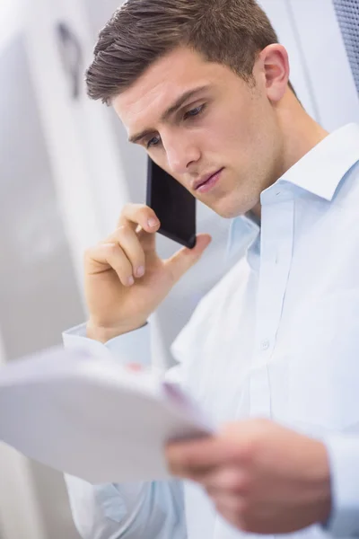 Técnico llamando y leyendo documento — Foto de Stock