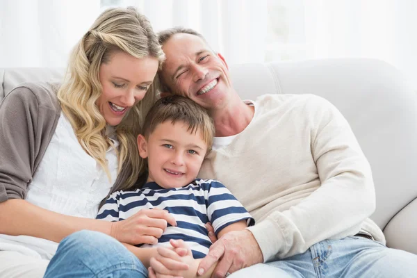 Ouders kietelen schattig zoon op Bank — Stockfoto