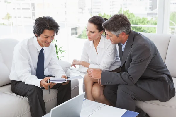 Business team looking over notes — Stock Photo, Image