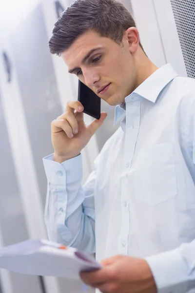 Technician calling and reading document — Stock Photo, Image