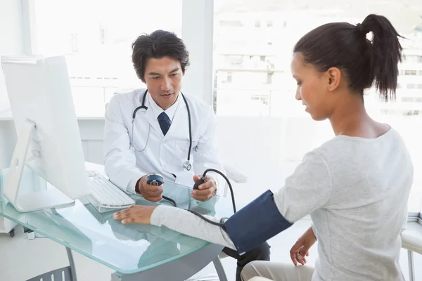 Médico tomando pacientes presión arterial — Foto de Stock