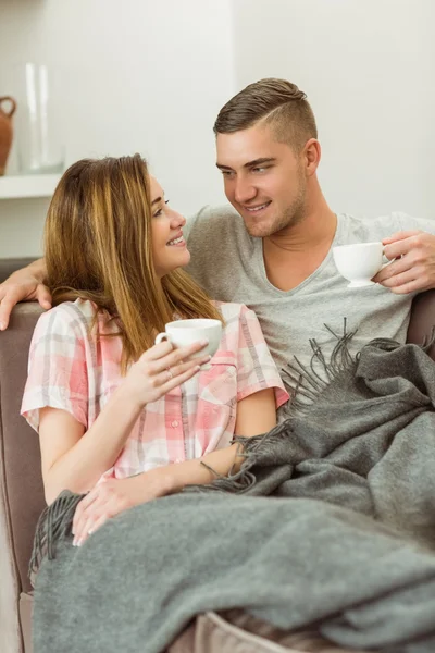 Casal relaxante no sofá com café — Fotografia de Stock