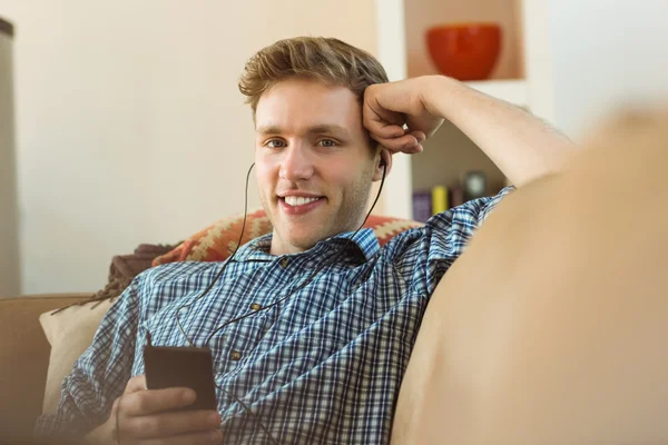 Hombre escuchando música en el sofá — Foto de Stock