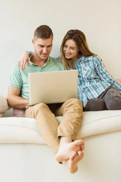 Couple relaxant sur canapé avec ordinateur portable — Photo