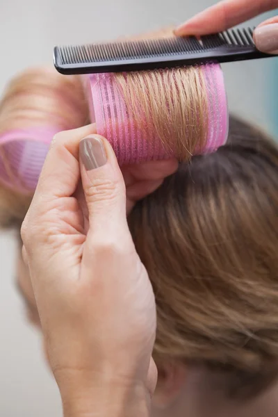 Kapper instelling krulspelden in haar — Stockfoto