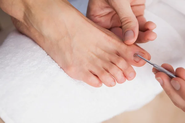 Pedicurist cleaning customers toe nails — Stock Photo, Image