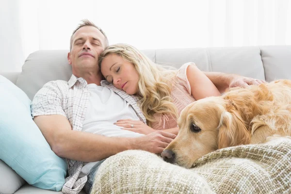 Casal cochilando no sofá com cão — Fotografia de Stock