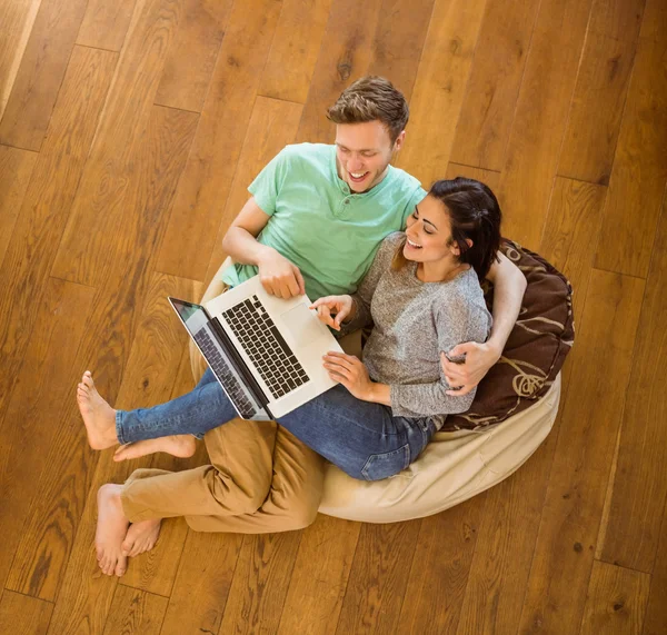 Casal usando laptop em saco de feijão — Fotografia de Stock