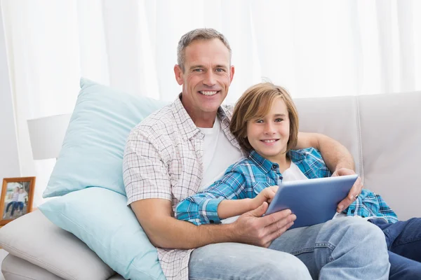 Father with son relaxing on couch — Stock Photo, Image