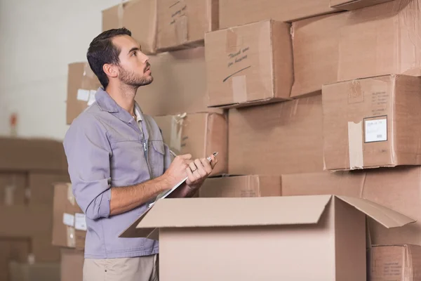 Worker with clipboard in warehouse — Stock Photo, Image