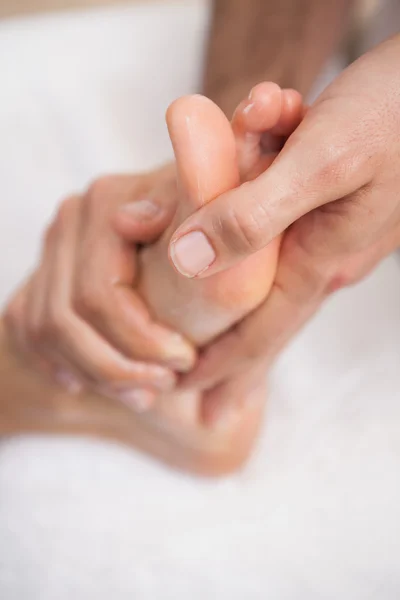 Pedicurista masajeando pie femenino — Foto de Stock