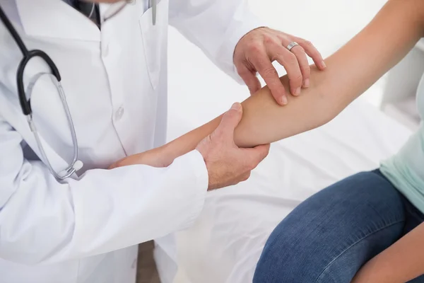 Läkare undersöka patienter arm — Stockfoto