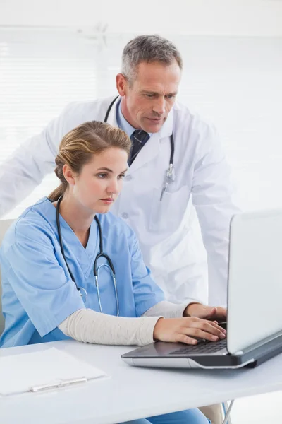 Nurse and doctor working on laptop — Stock Photo, Image