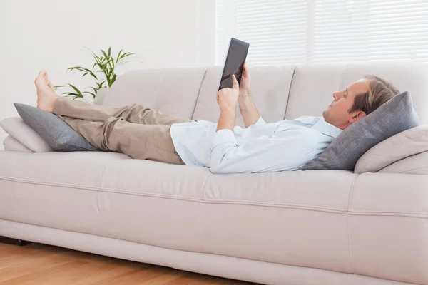 Hombre usando la tableta PC en el sofá — Foto de Stock