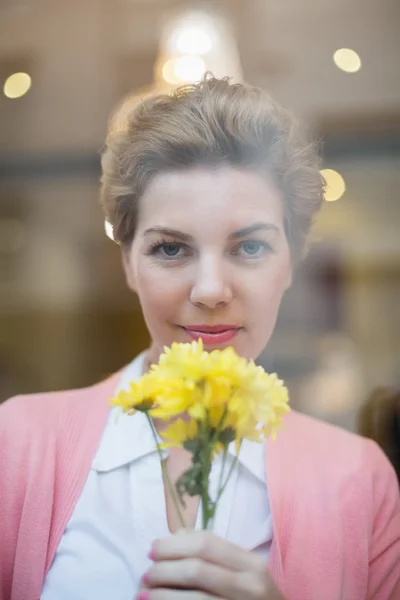 Woman smelling yellow flowers — Stock Photo, Image