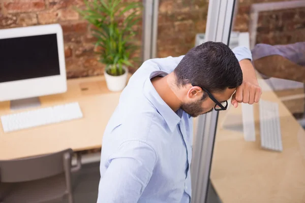 Empresario de pie contra la pared de vidrio — Foto de Stock