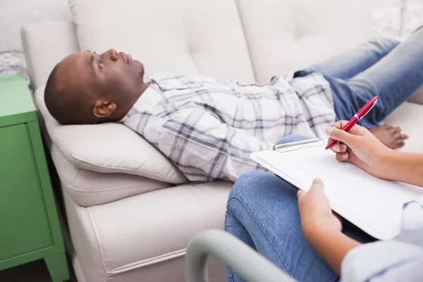 Man lying on sofa talking to therapist — Stock Photo, Image