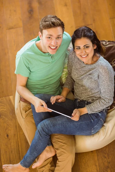 Para przy użyciu komputera typu tablet na beanbag — Zdjęcie stockowe