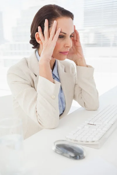 Businesswoman grasping head — Stock Photo, Image