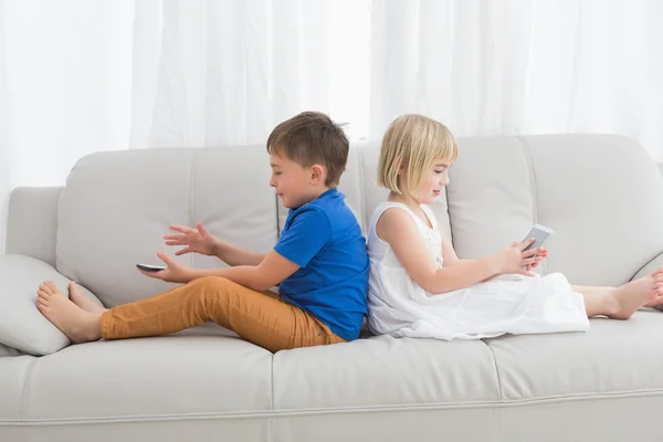 Broers en zussen met behulp van mobiele telefoon — Stockfoto