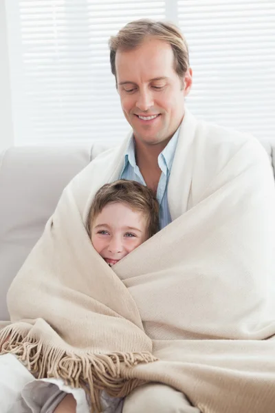 Père et fils enveloppés dans une couverture — Photo