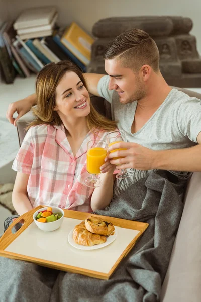 Пара отдыхает на диване с завтраком — стоковое фото