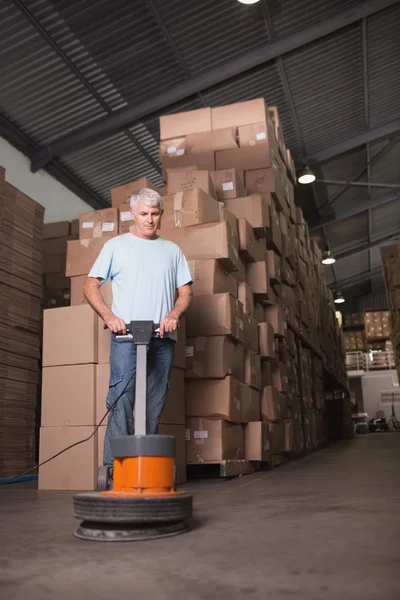 Man cleaning warehouse floor — Stock Photo, Image