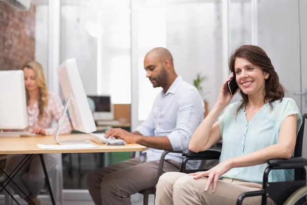 Zakenvrouw in rolstoel texting op telefoon — Stockfoto