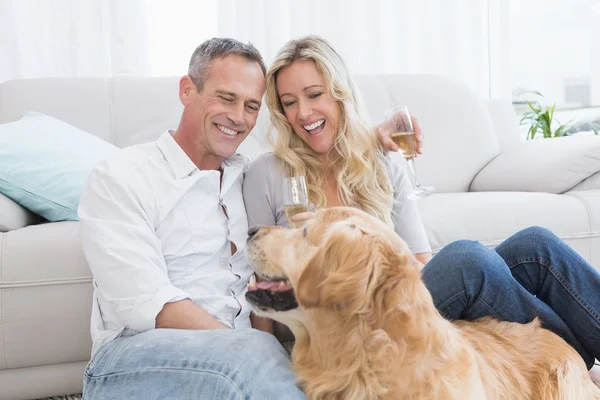 Пара пьет шампанское с собакой — стоковое фото
