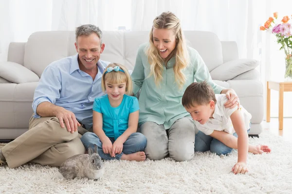 Familie met konijn op tapijt — Stockfoto