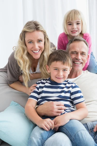Uśmiechnięta rodzina siedzi na kanapie — Zdjęcie stockowe