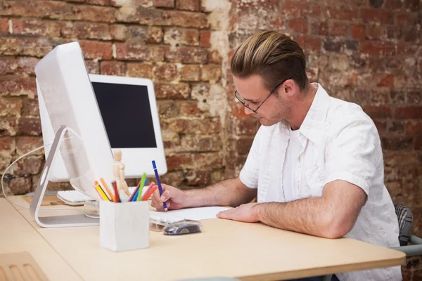 Geschäftsmann macht sich am Computer Notizen — Stockfoto