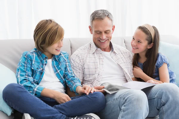 Familie op Bank verhalenboek lezen — Stockfoto