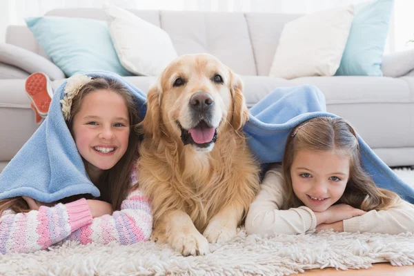Siostry, leżąc na dywanie z pies — Zdjęcie stockowe