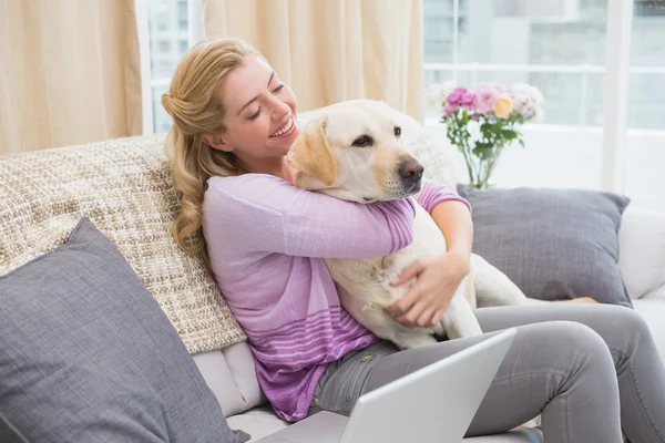 Mujer en sofá con perro mascota — Foto de Stock