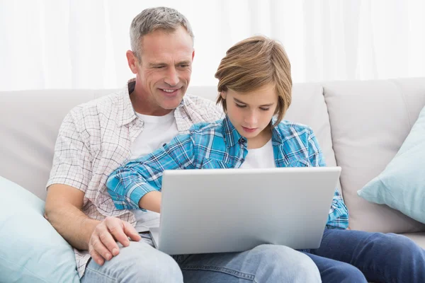 Father with son sitting on couch — Stock Photo, Image