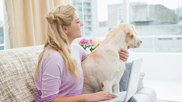 Mujer en sofá con perro mascota — Foto de Stock