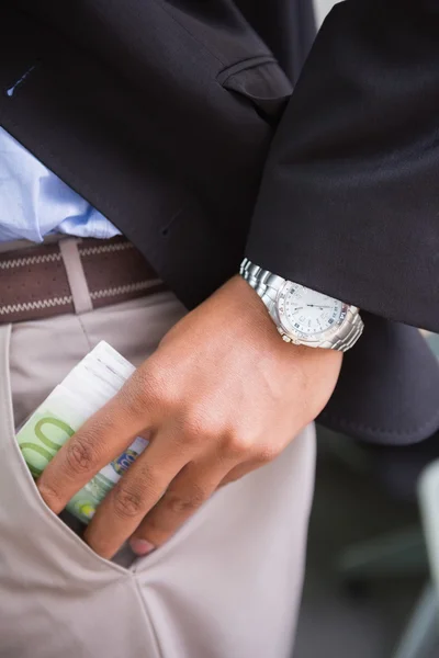 Hombre de negocios mantener la moneda en el bolsillo —  Fotos de Stock