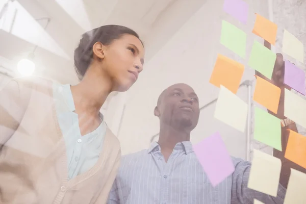 Equipo de negocios apuntando notas adhesivas — Foto de Stock