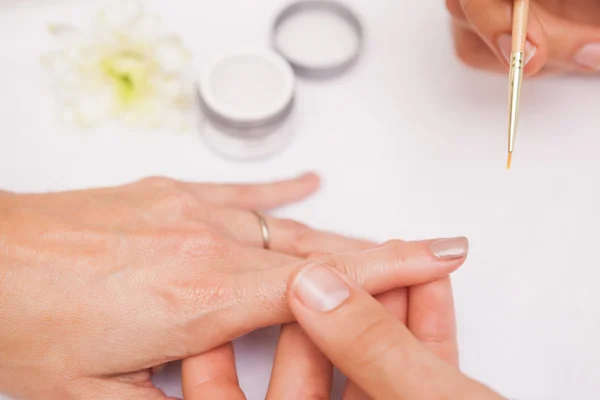 Manicura pintando las uñas de un cliente — Foto de Stock