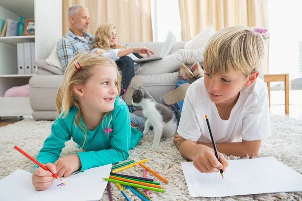 Siblings colouring and drawing on floor — Stock Photo, Image