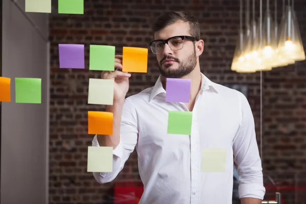 Businessman writing on sticky notes — Stock Photo, Image